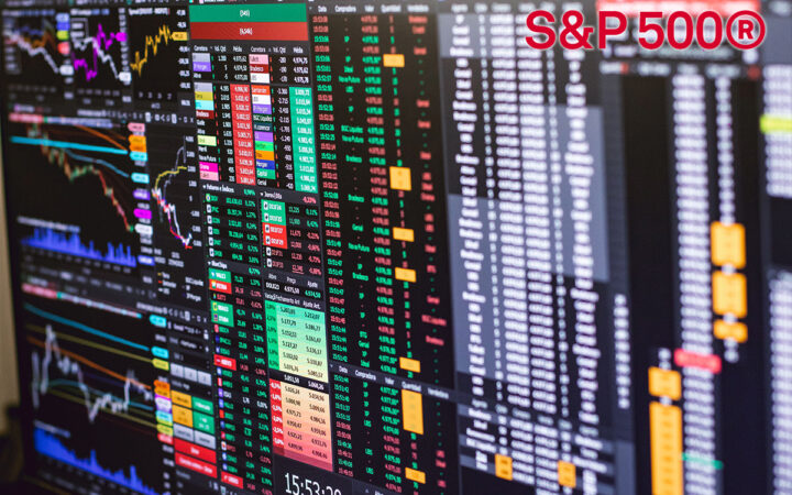 Wide view of multiple finance trading screens with colorful charts and a prominent S&P 500® logo in the upper-right corner.